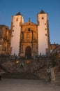 Cobblestone square with baroque church and staircase at dusk in Caceres