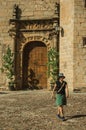 Tourist walking in front gothic church with wooden door at Caceres