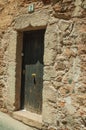 Old stone building facade with closed wooden door at Caceres