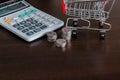 Caculator , Stack of coins and shopping trolley with copay space