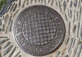 Cast iron manhole cover or gully cover on a street. Close up a manhole cover on road of Cadaques, Spain.