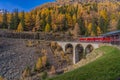 Bernina Express of Rhaetian Railway line on a autumn day in Switzerland cross a brigde