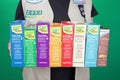 Cadette Girl Scout holding boxes of Girl Scout cookies on green background Royalty Free Stock Photo