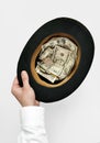 Cadger concept. Hand holding old top-hat with money Royalty Free Stock Photo