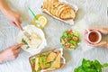 Caesar salad, bruschetta, ham and tomato sandwiches table with hands, top view from above Royalty Free Stock Photo