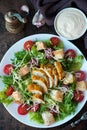 Caesar salad with chicken breast, croutons and parmesan sauce on a wooden table Royalty Free Stock Photo