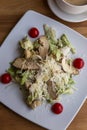 Caesar salad with chicken breast in a plate on the table. Appetizing dish. Close-up. Top view. Vertical Royalty Free Stock Photo