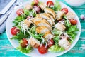Caesar salad with chicken breast on a rustic background, tomatoes, parmesan, green salad and croutons, selective focus Royalty Free Stock Photo