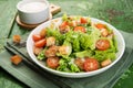 Caesar salad with chicken fillet, tomatoes, croutons and parmesan in a plate on a rustic wooden background Royalty Free Stock Photo