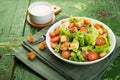 Caesar salad with chicken fillet, tomatoes, croutons and parmesan in a plate on a rustic wooden background Royalty Free Stock Photo