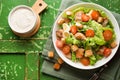 Caesar salad with chicken fillet, tomatoes, croutons and parmesan in a plate on a rustic wooden background Royalty Free Stock Photo