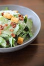 Caesar salad with crispy bread and bacon close up on wood background Royalty Free Stock Photo