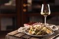 Caesar salad with croutons and egg served on a rustic wood with a glass of white wine Royalty Free Stock Photo