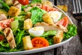 Caesar salad with croutons, quail eggs, cherry tomatoes and grilled chicken close up