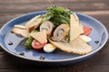 Caesar salad with croutons, quail eggs, cherry tomatoes and grilled chicken roll in a blue plate on a dark wooden table Royalty Free Stock Photo