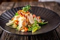 Caesar salad with fresh vegetables and crispy chicken on wooden background Royalty Free Stock Photo