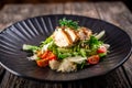 Caesar salad with fresh vegetables and crispy chicken on wooden background Royalty Free Stock Photo