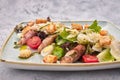 Caesar salad with herbs chicken bacon eggs and tomatoes on a square light plate, on a light background Royalty Free Stock Photo
