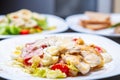 Caesar salad with parmesan,quail,bacon,white chicken meat served on white plate for dinner in Italian restaurant.Delicious natural Royalty Free Stock Photo