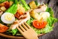 Caesar salad with quail eggs, cherry tomatoes and grilled chicken close up