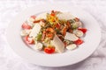 Caesar salad with quail eggs, cherry tomatoes, Parmesan cheese and grilled shrimps in white plate on light table. Royalty Free Stock Photo