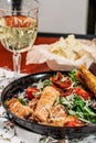 Caesar salad with salmon. Served with white wine. Salad with red fish fillet, cesar sauce, croutons, lettuce, cherry tomato, close