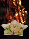 Caesar salad served in white plate in shape of star. Traditional dish in the restaurant - Caesar salad, fire on Royalty Free Stock Photo