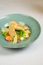 Caesar salad with shrimp on blue plate on white background Royalty Free Stock Photo