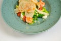 Caesar salad with shrimp on blue plate on white background Royalty Free Stock Photo