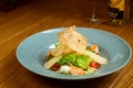 Caesar salad with shrimp on blue plate on wooden background Royalty Free Stock Photo