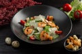 Caesar salad with shrimp on a dark wooden background