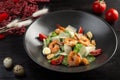 Caesar salad with shrimp on a dark wooden background