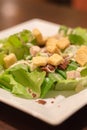 Caesar salad in white plate.