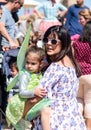 A young visitor of the Purim festival dressed in a fairy costume sits at her mom`s hands in Caesarea, Israel