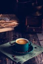 Cafe background with a green cup of espresso coffee standing on a linen napkin with a retro coffee grinder old book. Retro style N Royalty Free Stock Photo