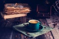 Cafe background with a green cup of espresso coffee standing on a linen napkin with a retro coffee grinder old book. Retro style N Royalty Free Stock Photo