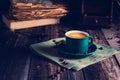 Cafe background with a green cup of espresso coffee standing on a linen napkin with a retro coffee grinder old book. Retro style N Royalty Free Stock Photo