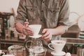 Cafe barista making specialty coffee using coffeee filter in a cafe