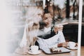 Cafe. Blond Girl. Mulatto. Sit. Drink Coffee. Royalty Free Stock Photo