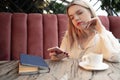 Cafe city lifestyle woman on phone drinking coffee texting text message on smartphone in trendy urban cafe. Royalty Free Stock Photo