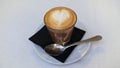 Cafe cortado, a traditional Spanish coffee served in transparent glass with a heart-shaped foam latte art on top