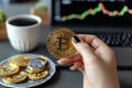 Cafe crypto Womans hand holds Bitcoin, smartphone reveals stock chart