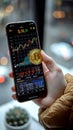 Cafe crypto Womans hand holds Bitcoin, smartphone reveals stock chart