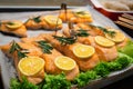 Cafe fast food display counter with tray of baked grilled tasty healthy red salmon fishfillet covered with lemon and