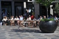 Cafe guests enjoy cold glass ans sun shin in outdoor cafe
