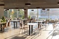 Cafe Interior. Modern cafe interior with bright room with tables and chairs nobody, large windows, modern style Royalty Free Stock Photo