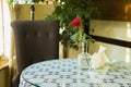 Cafe interior room day time with single rose flowers on table and empty chair