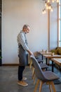 Waiter putting chairs in order in the cafe premises Royalty Free Stock Photo