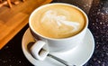Cafe latte cup on a black table surface. Drinking coffee in a cafe  cup on a saucer. Breakfast drink Royalty Free Stock Photo