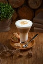 Cafe latte macchiato layered coffee in a glass cup.The cup is on a rustic Wooden Table Royalty Free Stock Photo